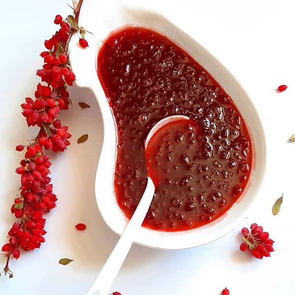 Homemade barberry jam in a bowl with dried barberries